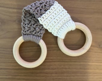 May include: A brown and white crocheted teething ring with two wooden rings.