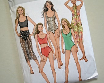 May include: A sewing pattern for five different swimsuit styles. The pattern includes a one-piece swimsuit with a scoop neck, a one-piece swimsuit with a V-neck, a one-piece swimsuit with a leopard print, a bikini top and bottom, and a sarong.