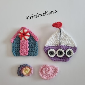 Peut inclure: Quatre appliqués au crochet comprenant une maison bleue et rose avec un accent circulaire rouge et blanc, un bateau violet et blanc avec trois hublots sombres et un drapeau rouge, un petit coquillage multicolore et un coquillage rose en spirale. Texte : KristineKeita.