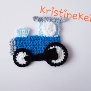 Peut inclure: Un train jouet en crochet bleu avec des roues noires et des accents blancs. Le train a une cheminée bleu clair et un cercle blanc pour une fenêtre.