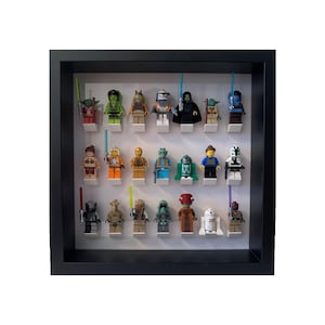 May include: A black framed shadow box display featuring 20 Star Wars Lego minifigures. The minifigures are arranged in two rows of ten. The minifigures include characters such as Yoda, Darth Vader, and Luke Skywalker.