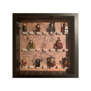 Può includere: Una teca nera a forma di scatola con un'immagine della Terra di Mezzo e 11 minifigure Lego del Signore degli Anelli. Le minifigure includono Gandalf, Aragorn, Legolas, Gimli, Frodo, Sam, Merry, Pippin, Gollum e due orchi.