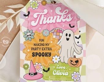 May include: A gift tag with a retro Halloween theme. The tag features a ghost, pumpkin, witch hat, and the words "Thanks" and "For making my party extra spooky." The tag is tied to a wrapped gift with a white ribbon.