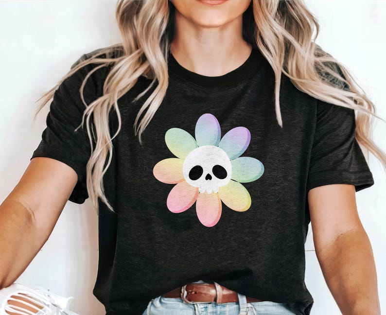 Pode incluir: Uma camiseta preta com um gr&aacute;fico de flor arco-&iacute;ris com uma caveira branca no centro.