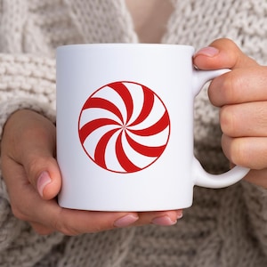 Puede incluir: Taza de cer&aacute;mica blanca con un dise&ntilde;o de caramelo de menta rojo y blanco.