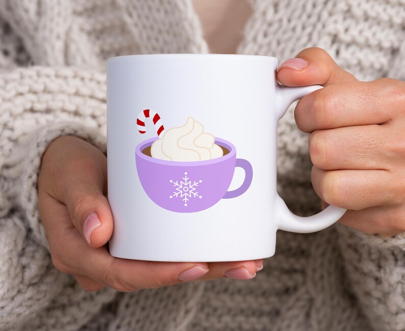 May include: White ceramic mug with a purple design of a mug of hot chocolate with whipped cream and a candy cane. The mug has a snowflake design.
