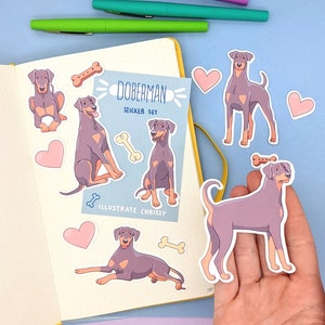 May include: A set of Doberman Pinscher dog stickers. The stickers are illustrated in a cartoon style and feature different poses of the dogs. The stickers are on a white background with the text "Doberman Sticker Set" and "Illustrate Chrissy".