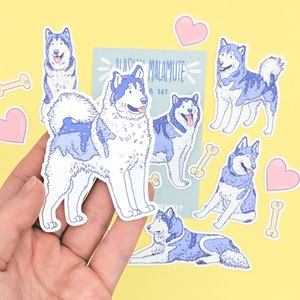Puede incluir: Un conjunto de ocho pegatinas de perros Alaskan Malamute. Las pegatinas est&aacute;n en varias poses y presentan un pelaje azul y blanco. Las pegatinas est&aacute;n sobre un fondo amarillo con algunos huesos y corazones blancos.