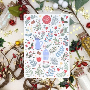 May include: A white card with a red circle that says "Illustrate Classy" and a pattern of blue, green, and red floral designs. The card is surrounded by gold stars, red berries, and green leaves.