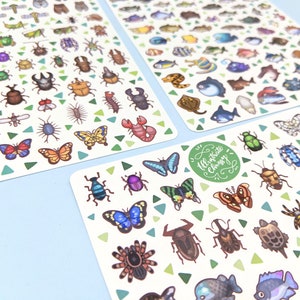 Peut inclure: Trois feuilles d'autocollants illustrant des insectes, des poissons et d'autres créatures colorés. Les autocollants sont sur un fond blanc avec des motifs de triangles verts. Le texte "Illustrate Choosy" est imprimé sur l'une des feuilles.