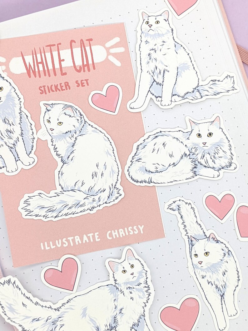 May include: A sticker set featuring illustrations of white cats in various poses, with pink heart stickers. The set includes a card that reads "WHITE CAT STICKER SET" and "ILLUSTRATE CHRISSY" on a pink background.
