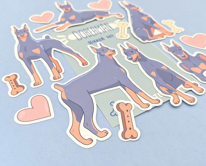 May include: A set of Doberman Pinscher dog stickers. The stickers are in various poses, including sitting, standing, and running. The stickers are on a light blue background with a white border. The stickers are part of a sticker set called "Doberman Sticker Set".