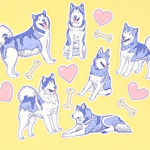 Puede incluir: Un conjunto de seis pegatinas de perros husky azules y blancos con pegatinas de corazones rosas y huesos. Las pegatinas est&aacute;n sobre un fondo amarillo.