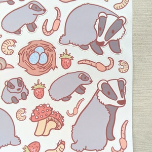 K&ouml;nnte beinhalten: Eine Bogen mit Aufklebern mit Illustrationen von Dachsen, Schnecken, Erdbeeren, Pilzen und W&uuml;rmern. Die Aufkleber sind in verschiedenen Farben, darunter rosa, rot, braun und gr&uuml;n.