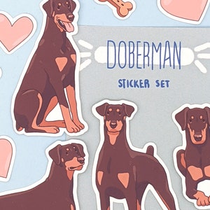 May include: A sticker set featuring Doberman Pinschers. The set includes four stickers of brown Dobermans in different poses, two pink hearts, a bone, and a title card that reads "Doberman Sticker Set".