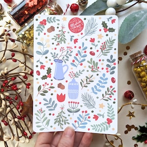 May include: A white card with a red circle that says "Ultimate Christmas" and a pattern of blue and green leaves, red berries, and white flowers. There are also blue and white vases and red tulips.