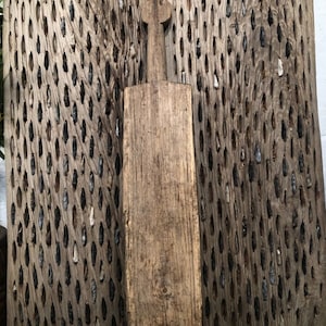 May include: A rustic wooden chopping board with a long, narrow shape and a rounded handle. The board is weathered and has a natural wood finish.