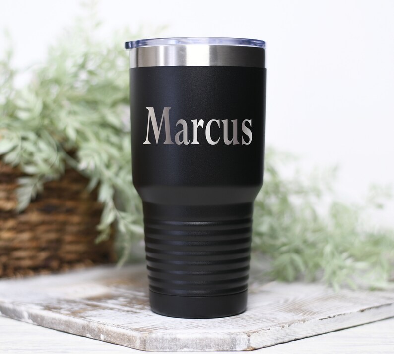 May include: Black stainless steel tumbler with a silver engraved name "Marcus".