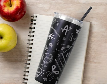 Puede incluir: Taza de acero inoxidable negra con un diseño blanco de útiles escolares, que incluye un lápiz, una regla, unas tijeras, un avión de papel, una bombilla y las palabras "A+" y "12".