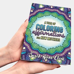 May include: A purple, green and blue colouring book with the title "A Year of Colouring Affirmations for New Mothers" by Sarah Renae Clark.