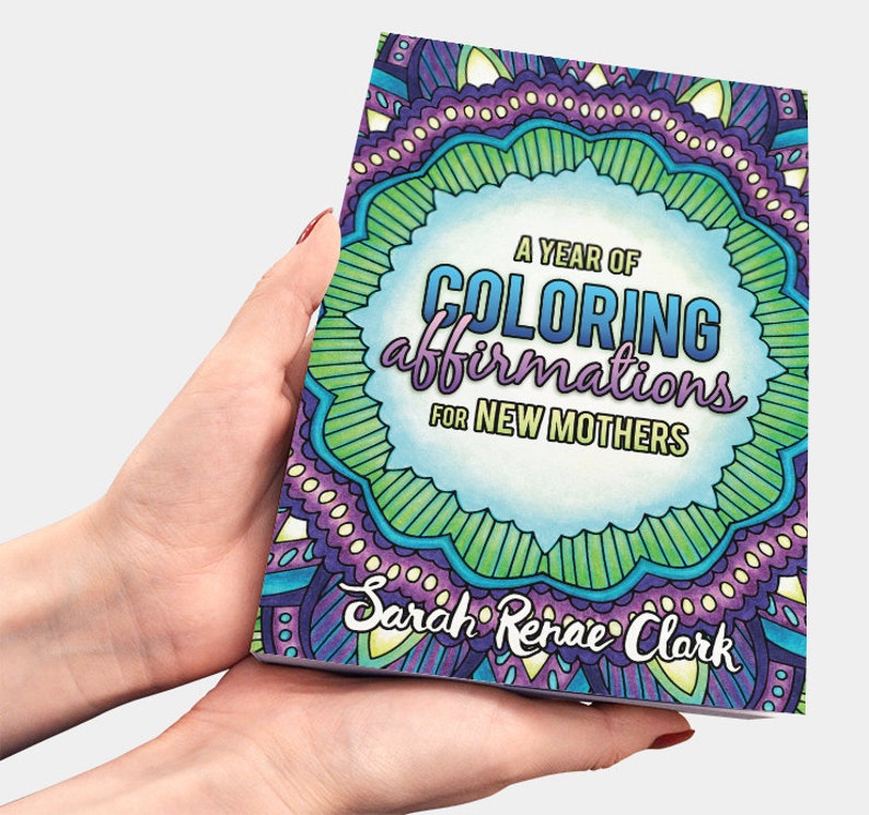 May include: A purple, green and blue colouring book with the title "A Year of Colouring Affirmations for New Mothers" by Sarah Renae Clark.
