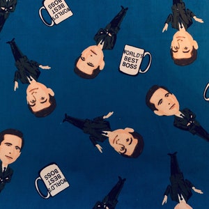 May include: A blue fabric with a repeating pattern of a cartoon man with a mug that says "World's Best Boss".