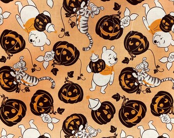 Halloween Disney Winnie the Pooh Fabric featuring Winnie on an orange background surrounded by pumpkin jack o lanterns, Licensed fabric