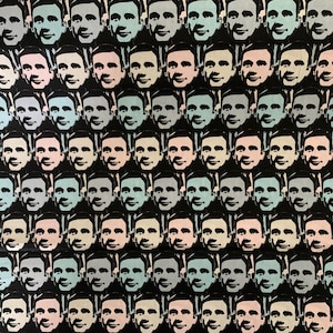 May include: A black and white pattern of repeated faces with different colored skin tones. The faces are all smiling and have a similar expression. The background is black.