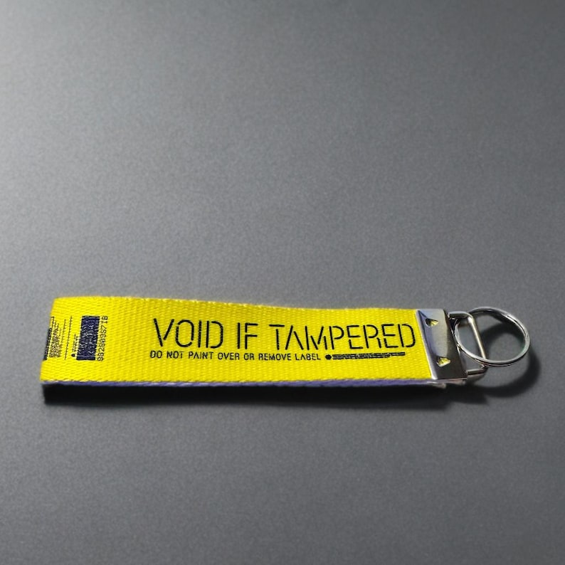 Yellow wristlet keychain for keys  with the words "Void If Tampered"