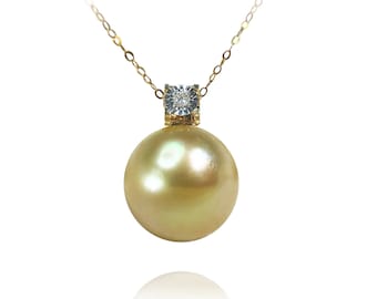 Könnte beinhalten: Eine goldene Kettenkette mit einem goldenen Anhänger, der eine große, runde, goldene Perle und einen kleinen, quadratischen, klaren Diamanten trägt.