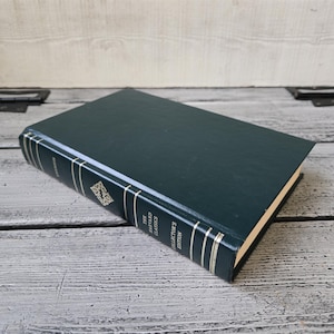 May include: A dark green hardback book with gold lettering on the spine. The title is "The Oxford Classics Collector's Edition Volume 1 The Iliad and The Odyssey".