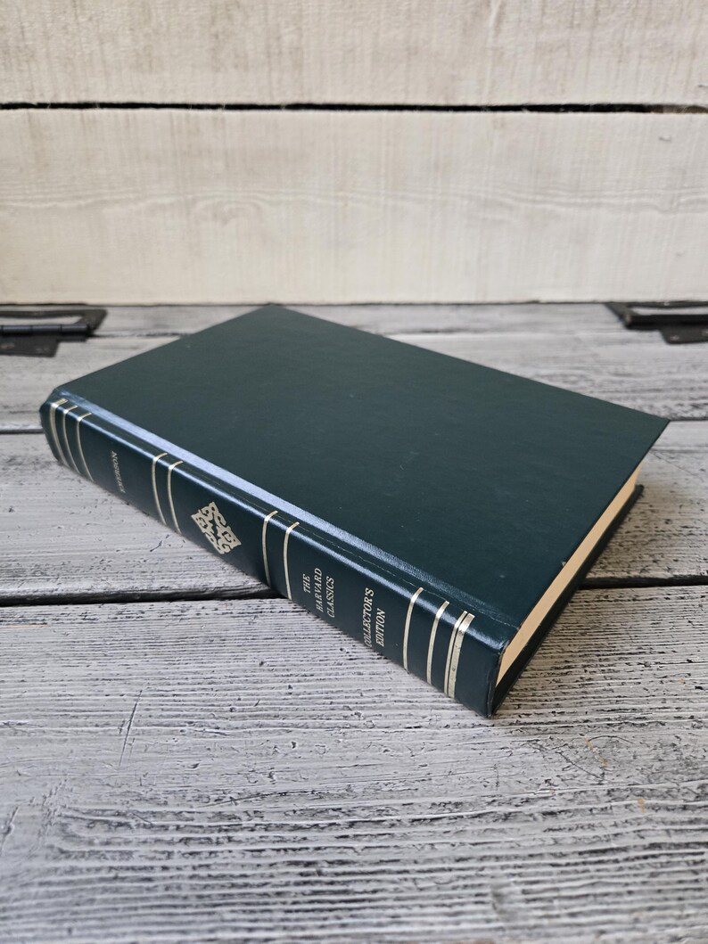 May include: A dark green hardback book with gold lettering on the spine. The title is "The Oxford Classics Collector's Edition Volume 1 The Iliad and The Odyssey".