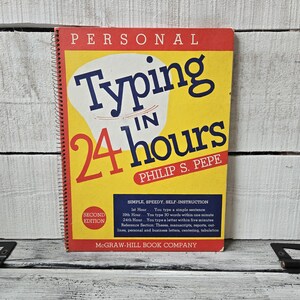 May include: A vintage book titled "Typing in 24 Hours" by Philip S. Pepe. The book cover is yellow with red and blue text. It is a second edition and features a simple, speedy, self-instruction guide.