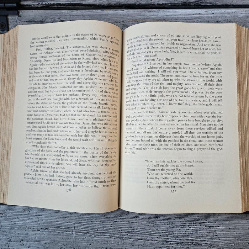May include: Open book with text on aged paper. The pages display a story about ancient gods and goddesses, with the text and page numbers visible. The book is open, revealing the story's narrative.