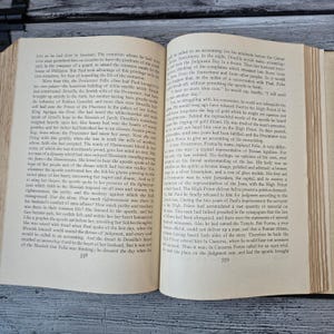 May include: Open book with aged, yellowed pages. The text is in black ink, with a serif font. The book is open to two pages, with text filling the majority of the space. The book is likely an antique or vintage item.