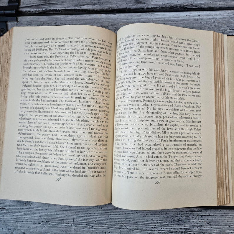 May include: Open book with aged, yellowed pages. The text is in black ink, with a serif font. The book is open to two pages, with text filling the majority of the space. The book is likely an antique or vintage item.
