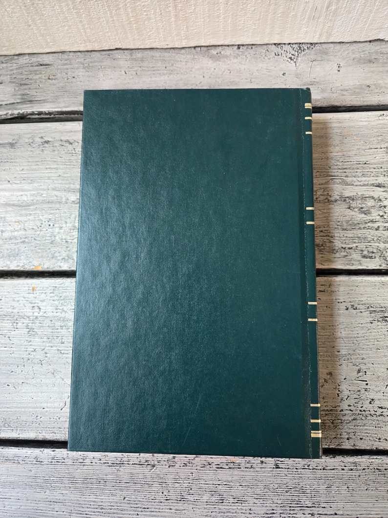 May include: A dark green hardback book with gold accents along the spine.
