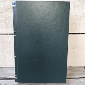 May include: A dark green hardback book with gold accents on the spine.