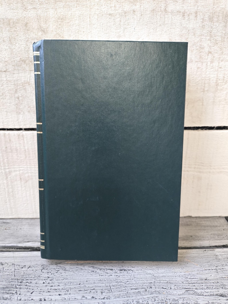 May include: A dark green hardback book with gold accents on the spine.