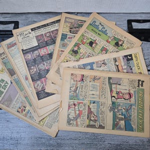 May include: A collection of vintage comic book pages, featuring colorful illustrations and text. The pages display various comic strips, including "Little Lulu," "Daffy Duck," and "Bugs Bunny." Some pages have advertisements for jewelry. The pages are aged with a yellowed appearance.