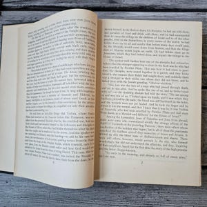 May include: Open book with text on aged paper. The pages are yellowed, and the text is in a serif font. The book is open to a chapter discussing religious figures and events. The book is likely a historical or religious text.