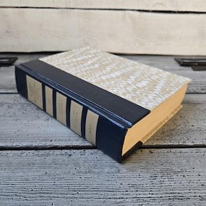May include: A hardback book with a marbled cover and a dark blue spine. The title of the book is "The Complete Works of Oscar Wilde" and the author is "Oscar Wilde".