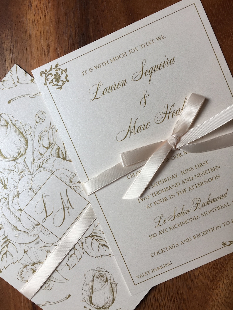 May include: Ivory wedding invitation with gold script text and a cream ribbon. The invitation includes the names Lauren Sequeira & Marc Heal, and event details. A floral design is on the envelope.