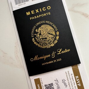 May include: Black passport-style wedding invitation with gold foil lettering. The invitation reads "Mexico Pasaporte" and features the names "Monique & Lester" and the date "November 29, 2025". A boarding pass is tucked inside.