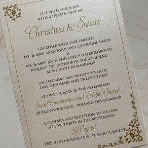 May include: Ivory wedding invitation with gold script. The invitation includes the names "Christina & Sean", event details, and floral corner accents. The text reads "Request the honour of your presence as we unite in marriage."