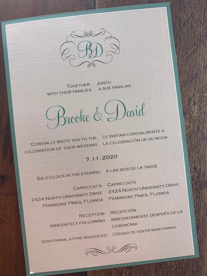 May include: A wedding invitation with a green border and a cream background. The invitation features a monogram of the letters "BD" in a decorative font. The text reads "Brooke & David" in a green cursive font. The invitation details the wedding date, time, location, and dress code.