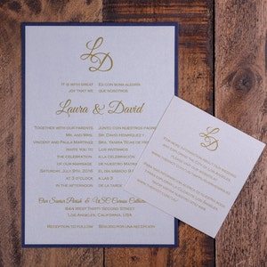 May include: A wedding invitation with a blue border and a gold monogram of the letters "LD". The invitation is for Laura and David and includes the date and time of the wedding ceremony and reception. The text is in both English and Spanish.