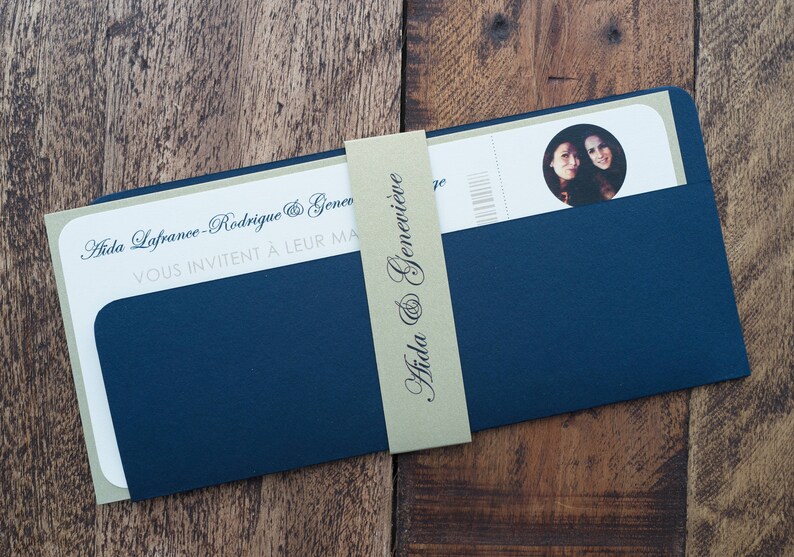 May include: A navy blue wedding invitation suite with a light green backing. The invitation features the names "Aida & Genevieve" on a light green band. The invitation includes a photo of two people.