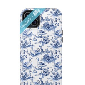 Pu&ograve; includere: Una custodia per telefono bianca con un motivo blu e bianco di anatre e fiori. La custodia ha un logo MagSafe+ sul retro.
