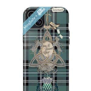 Może przedstawiać: Etui na telefon z zielono-czarnym wzorem w kratę. Etui posiada srebrny wzór celtyckiego węzła z tekstem, mieczem i ostem. Na etui wydrukowano słowa "MagSafe +".